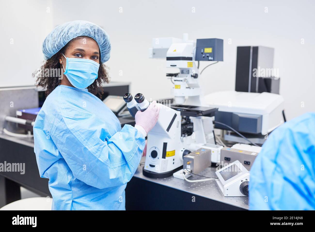 Femme africaine en tant que chercheur travaille sur le microscope dans Un laboratoire sur le vaccin Covid-19 contre la pandémie du coronavirus Banque D'Images