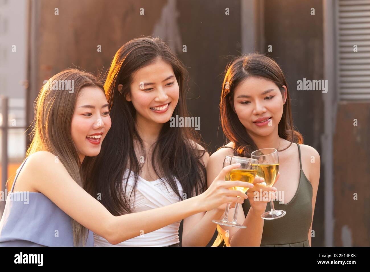 femme asiatique ados applaudissent et toast avec un verre de vin blanc mousseux à célébrer à dîner partie en été. célébration, relation et f Banque D'Images
