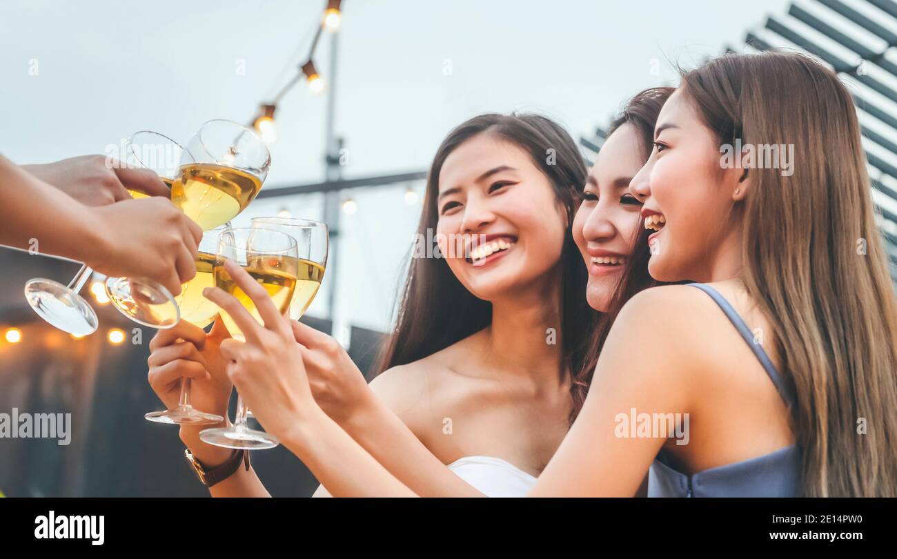 bonne femme asiatique ados applaudissent et toast avec un verre de vin blanc mousseux à célébrer à dîner de fête en été. attention sélective. célébrez Banque D'Images