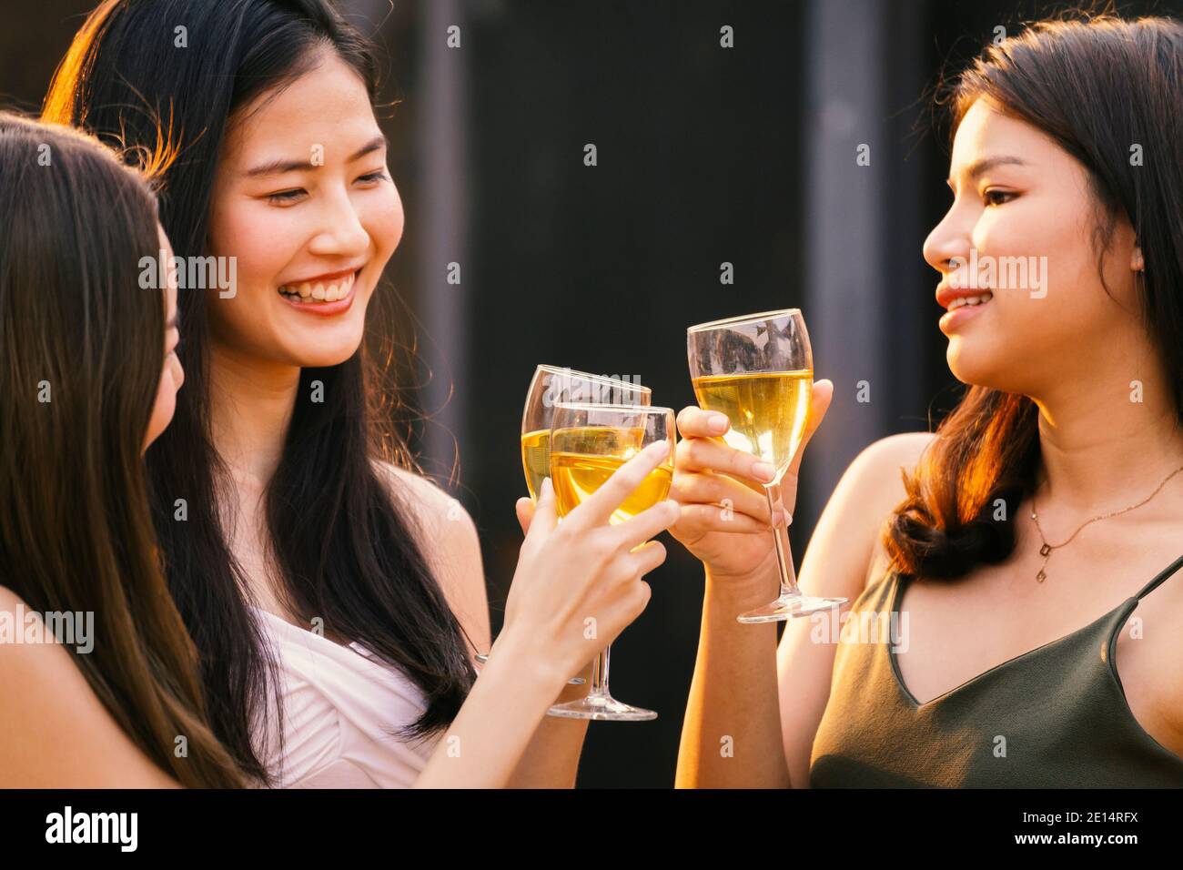bonne femme asiatique ados applaudissent et toast avec un verre de vin blanc mousseux à célébrer à dîner partie en été. célébration, relation Banque D'Images