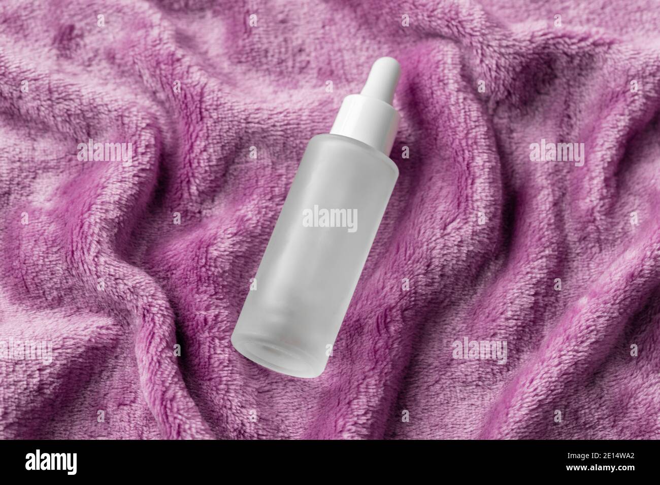 Sérum avec collagène et peptides plat confortable sur tissu doux rose confortable. Teinture d'acide hyaluronique, mockup. Concept de soins de beauté à domicile Banque D'Images