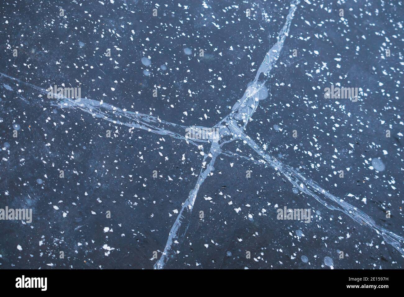 fissures dans la glace sur un étang gelé - vue rapprochée, texture de la glace Banque D'Images