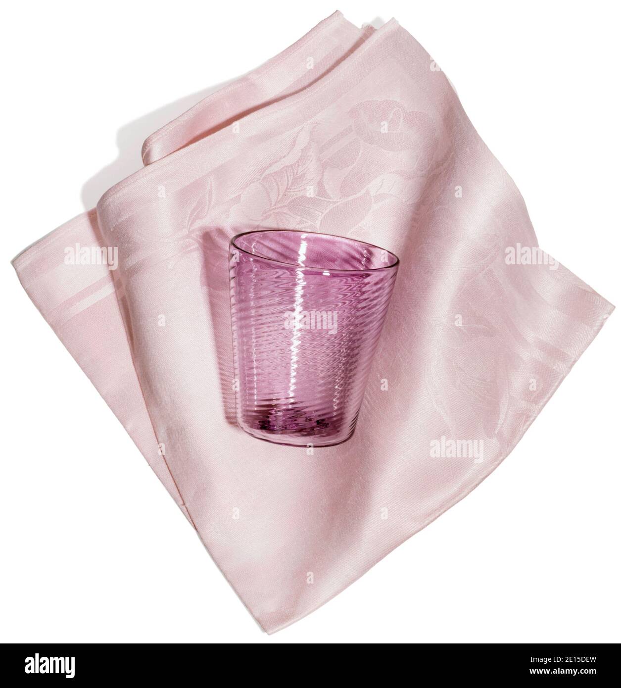 Serviette en verre et tissu rose photographiée sur fond blanc Banque D'Images
