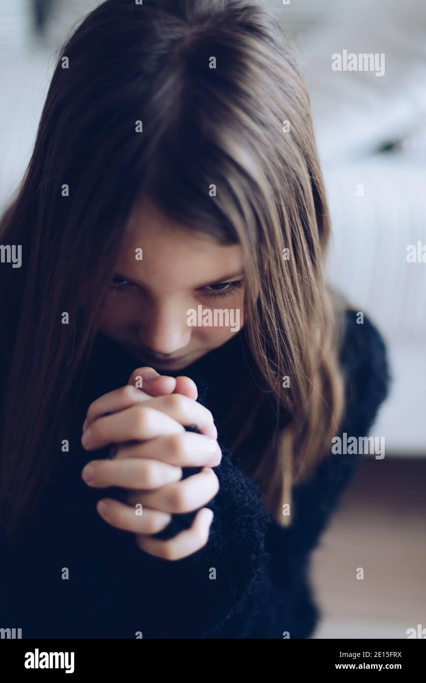 Petite fille avec ses mains repliées dans la prière. Banque D'Images