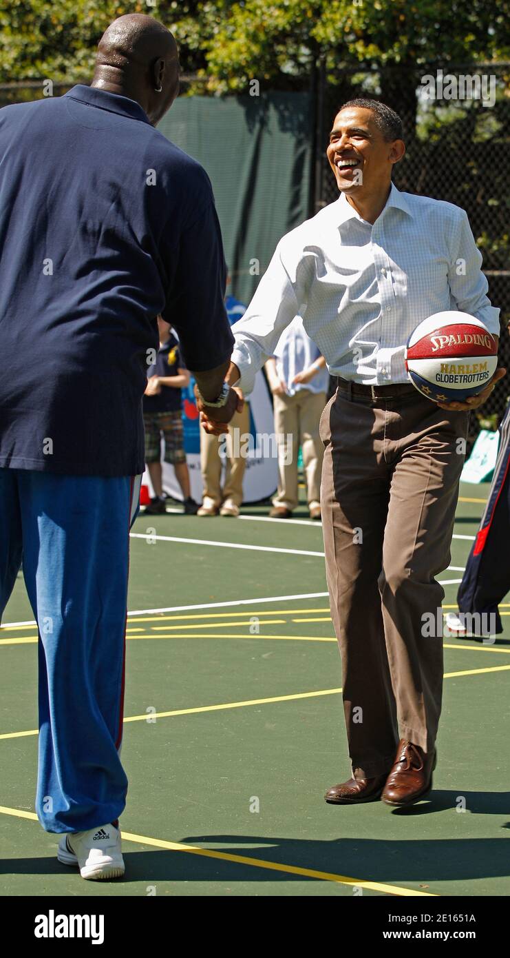 Le président américain Barack Obama (R) secoue hans avec le joueur à la  retraite de la NBA Darryl Dawkins tout en participant à une clinique de  basket-ball « let's Move » avec