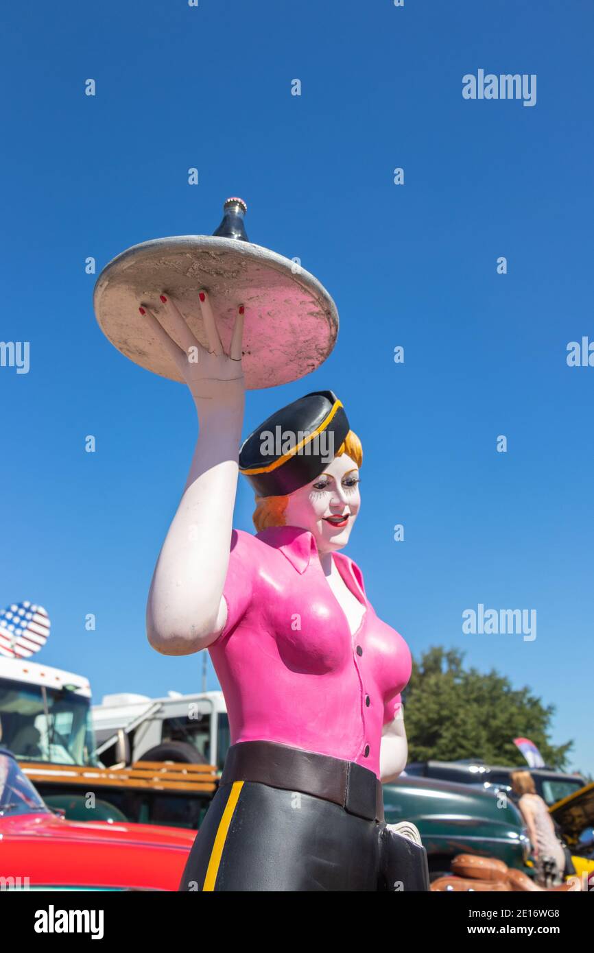 Mannequin d'époque d'un serveur de saut à la ligne féminin sur patins à roulettes avec coke sur un plateau au salon automobile américain classique Stars & Stripes Banque D'Images