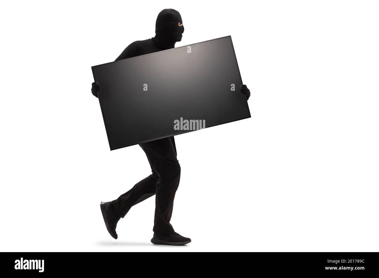 Cambrioleur avec un masque noir volant un téléviseur et courant isolé sur fond blanc Banque D'Images