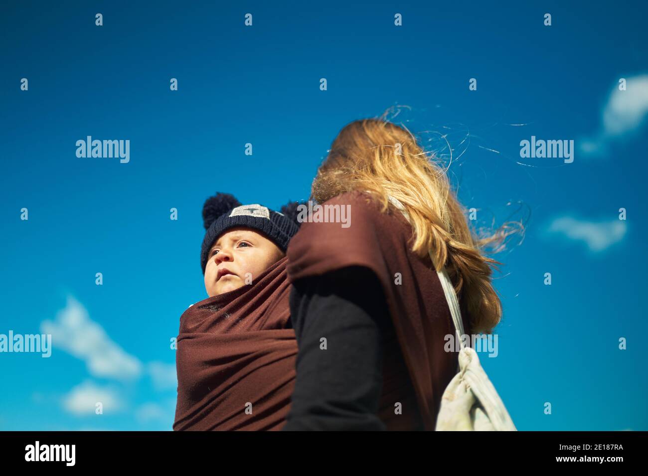 Une jeune mère profite de la nature avec son bébé une élingue Banque D'Images
