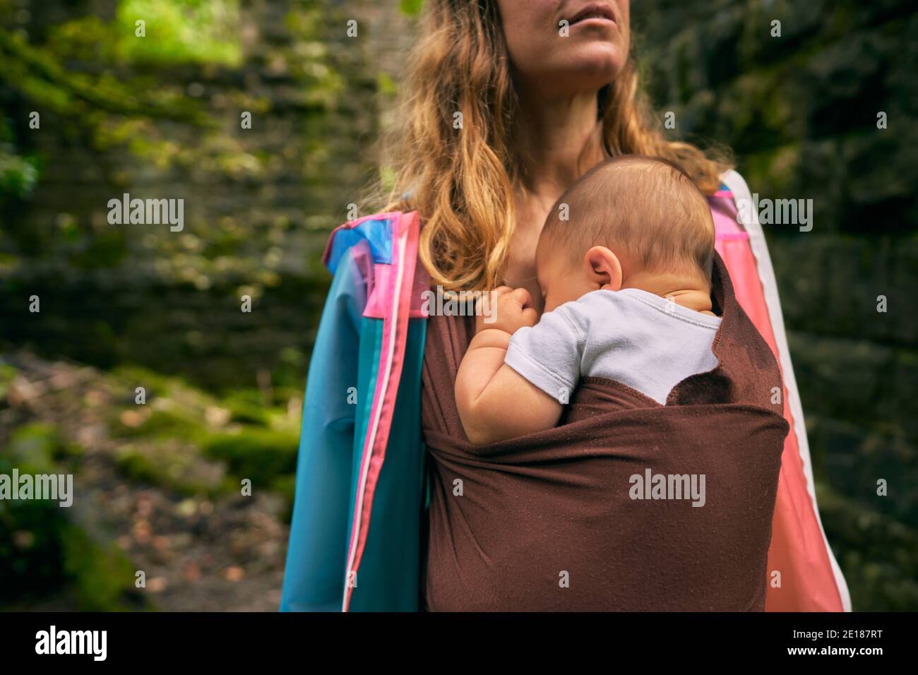 Une jeune mère profite de la nature avec son bébé une élingue Banque D'Images