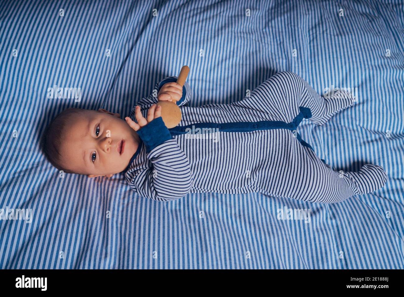 Un petit bébé est allongé sur un lit avec un cliquetis en bois Banque D'Images