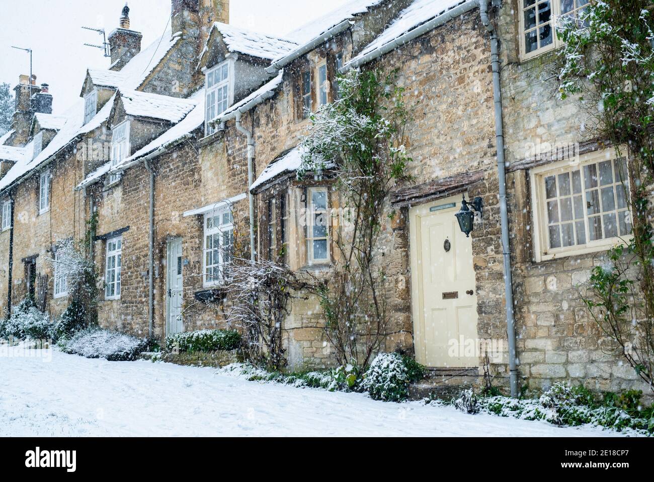 Rangée de Cotswold Stone Cottages sur Burford Hill dans la neige de décembre. Burford, Cotswolds, Oxfordshire, Angleterre Banque D'Images