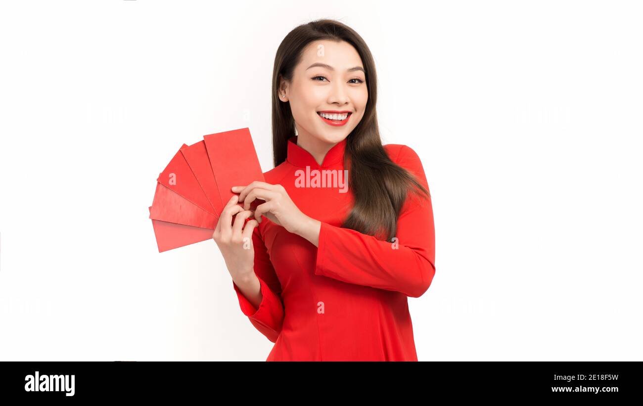 Fille asiatique dans le traditionnel et prendre des enveloppes rouges lunaire nouvelle année, concept célébrant le nouvel an lunaire ou le festival de tet, isolé sur fond blanc. Banque D'Images