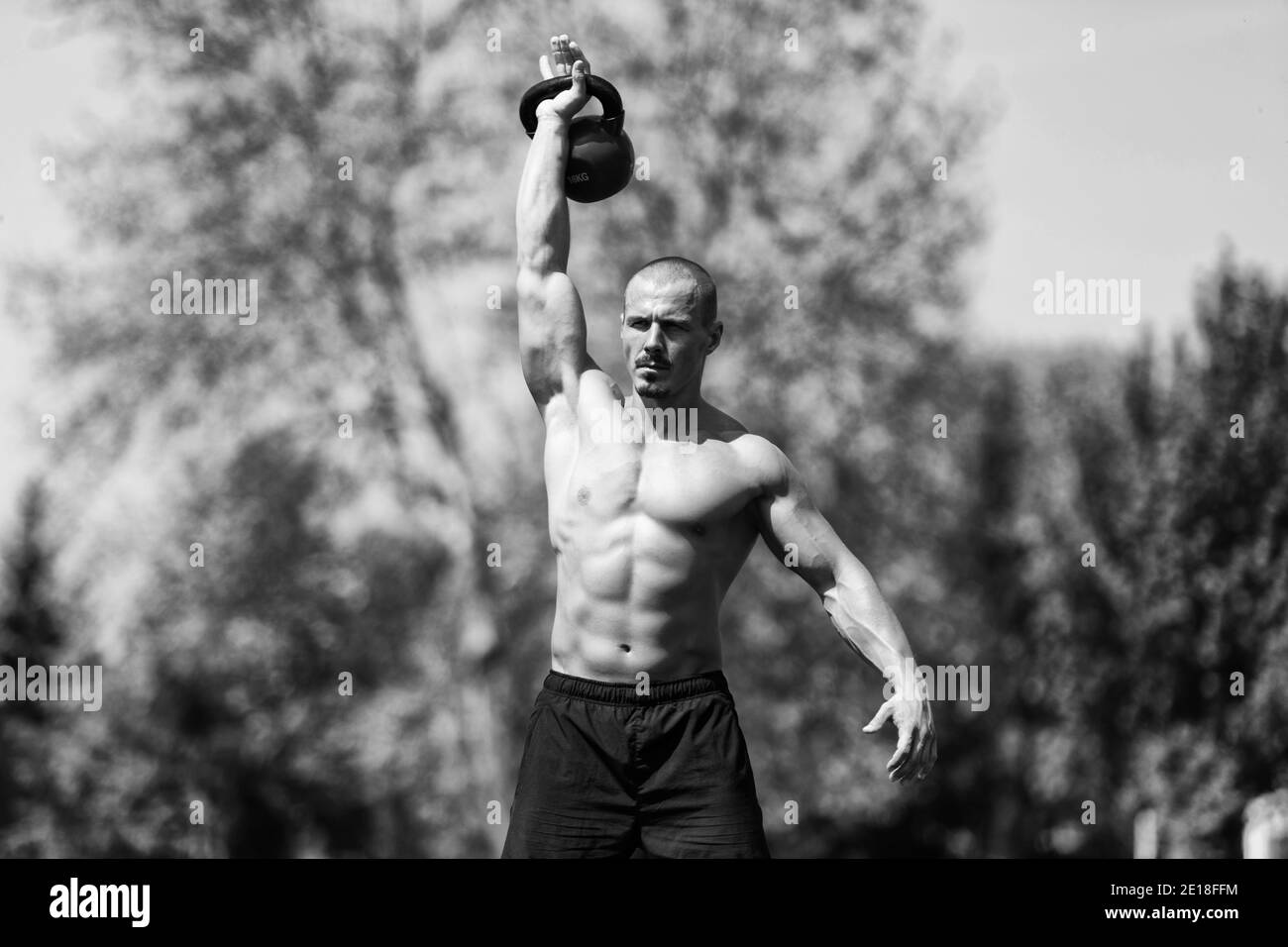Homme s'entraînant avec Kettle Bell extérieur et muscles flexibles - Exercices de modèle de forme physique musculaire Athletic Body Builder Banque D'Images