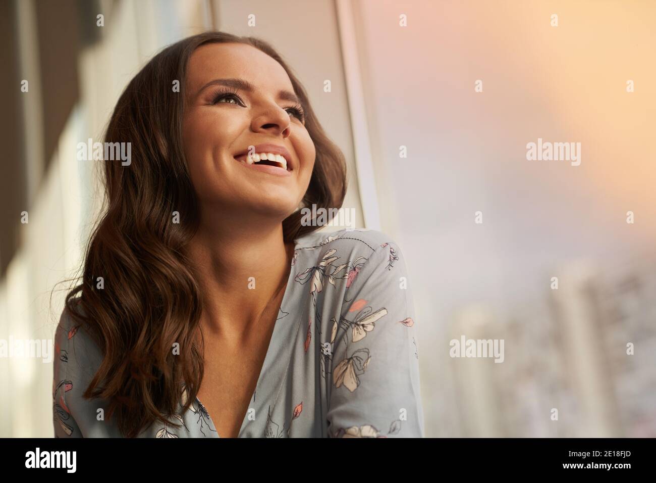 Belle jeune femme heureuse souriant regarde loin sur le fond de la ville. Photo de haute qualité Banque D'Images