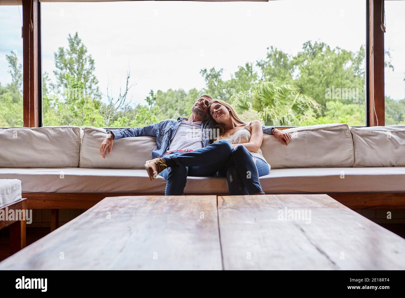 Smiling couple sitting on sofa Banque D'Images