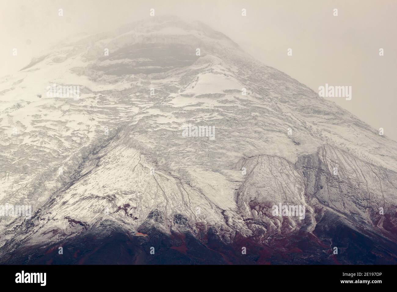 Le sommet du volcan Cotopaxi, en Équateur, après une chute de neige fraîche. Le refuge des grimpeurs est visible en bas à gauche. Banque D'Images