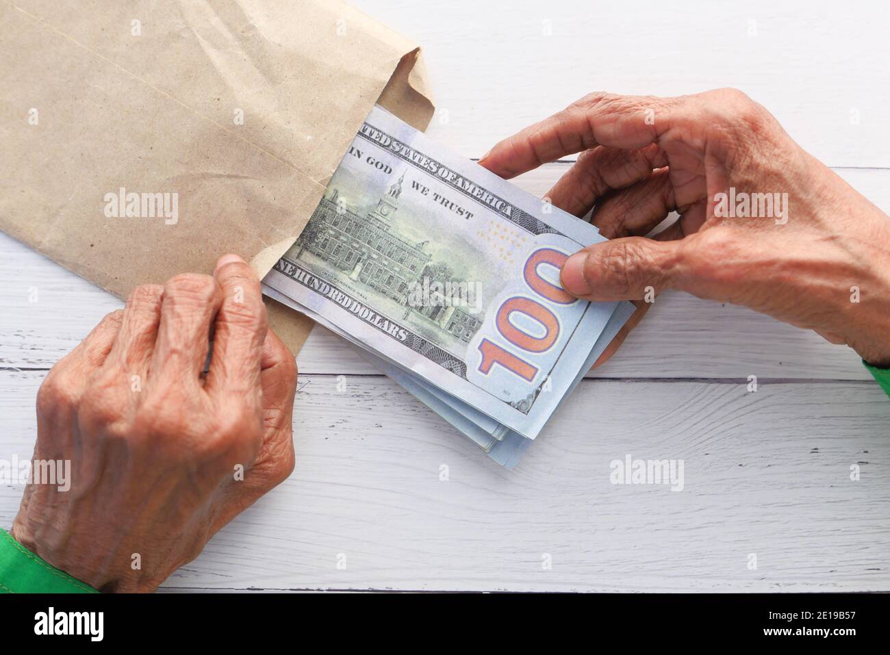 les femmes âgées mettent de l'argent dans une enveloppe. Banque D'Images