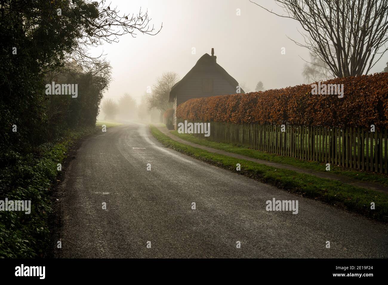 Route rurale étroite de campagne dans le brouillard épais et la brume à travers un petit village, dangereuses mauvaises conditions de conduite dans le brouillard brumeux sur les routes anglaises, les rues arrière en Angleterre, au Royaume-Uni Banque D'Images