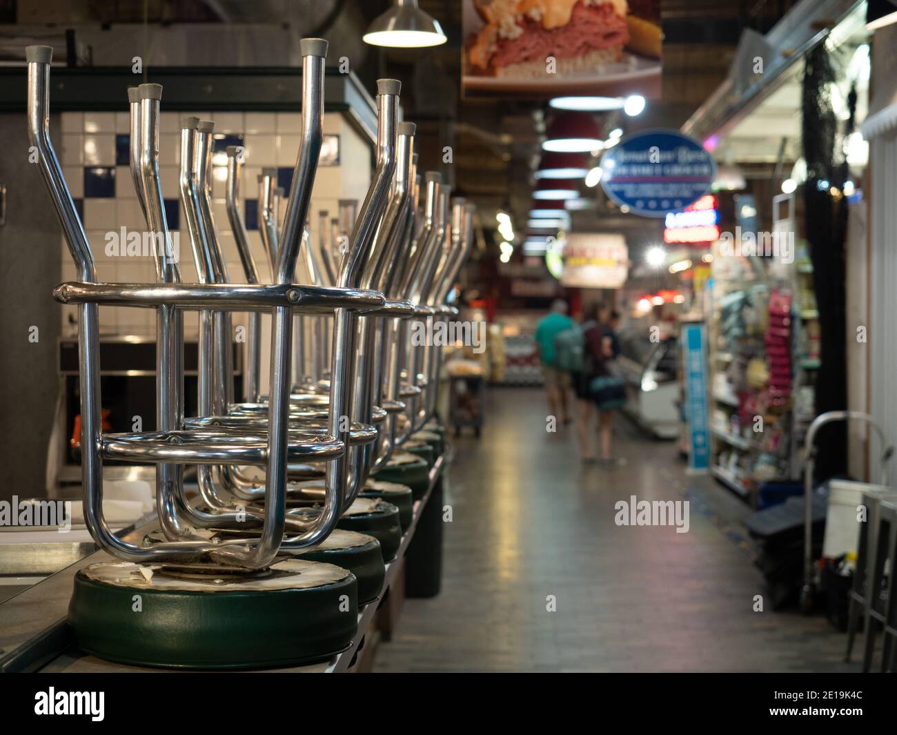 Une série de tabourets de bar empilés sur le comptoir d'un établissement fermé dans le marché du terminal de lecture. Banque D'Images