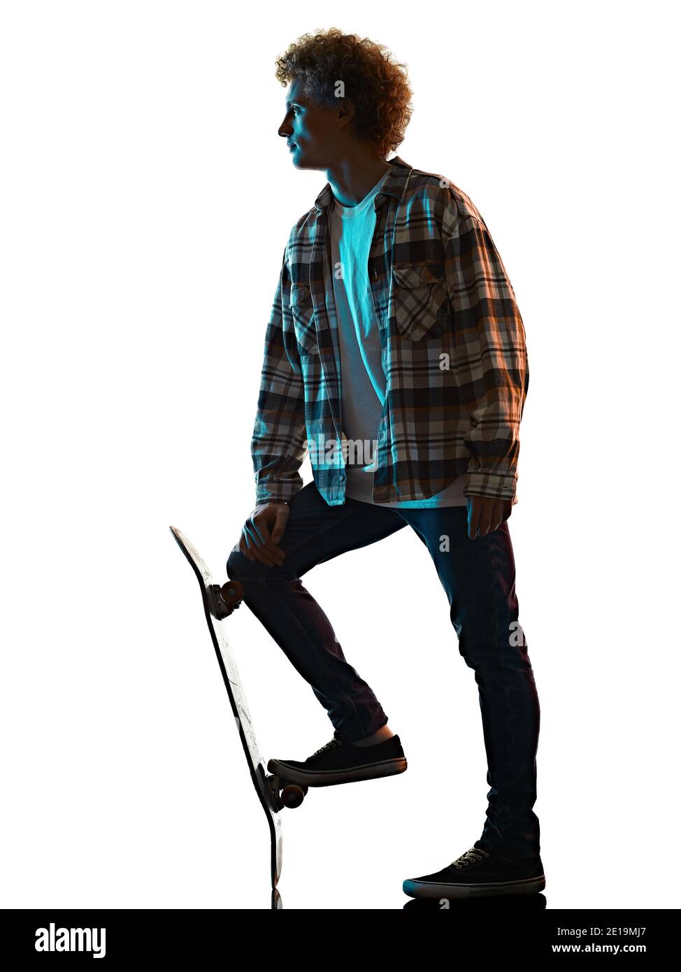 Un jeune homme caucasien skateboarder Skateboarding dans l'ombre de la silhouette de studio isolé sur fond blanc Banque D'Images