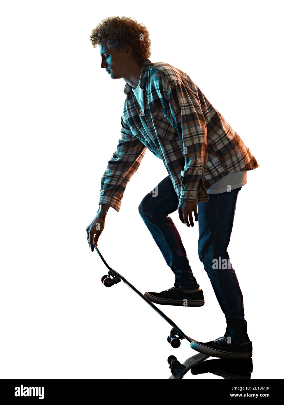 Un jeune homme caucasien skateboarder Skateboarding dans l'ombre de la silhouette de studio isolé sur fond blanc Banque D'Images