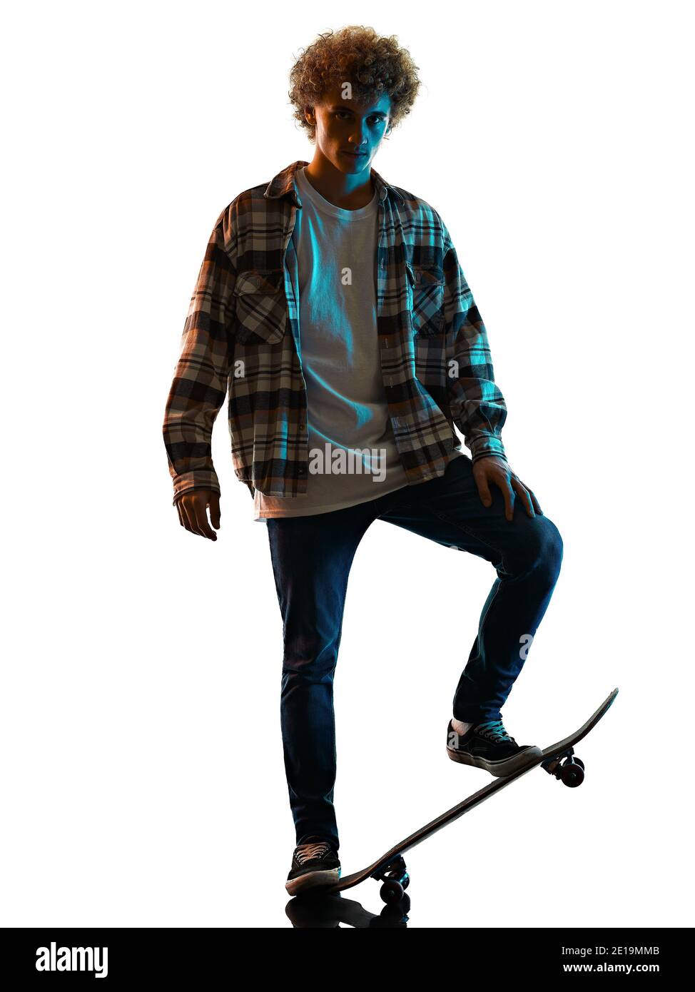 Un jeune homme caucasien skateboarder Skateboarding dans l'ombre de la silhouette de studio isolé sur fond blanc Banque D'Images