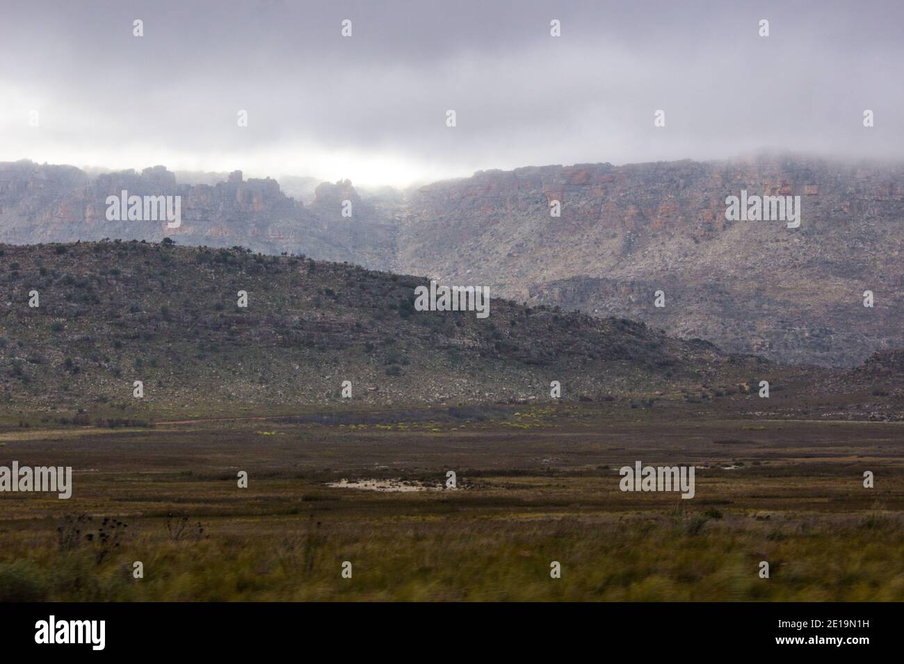 Lumière du soleil du matin perçant à travers les nuages de tempête inquiétants et illuminant les crêtes supérieures des montagnes Cederberg, Afrique du Sud, Banque D'Images