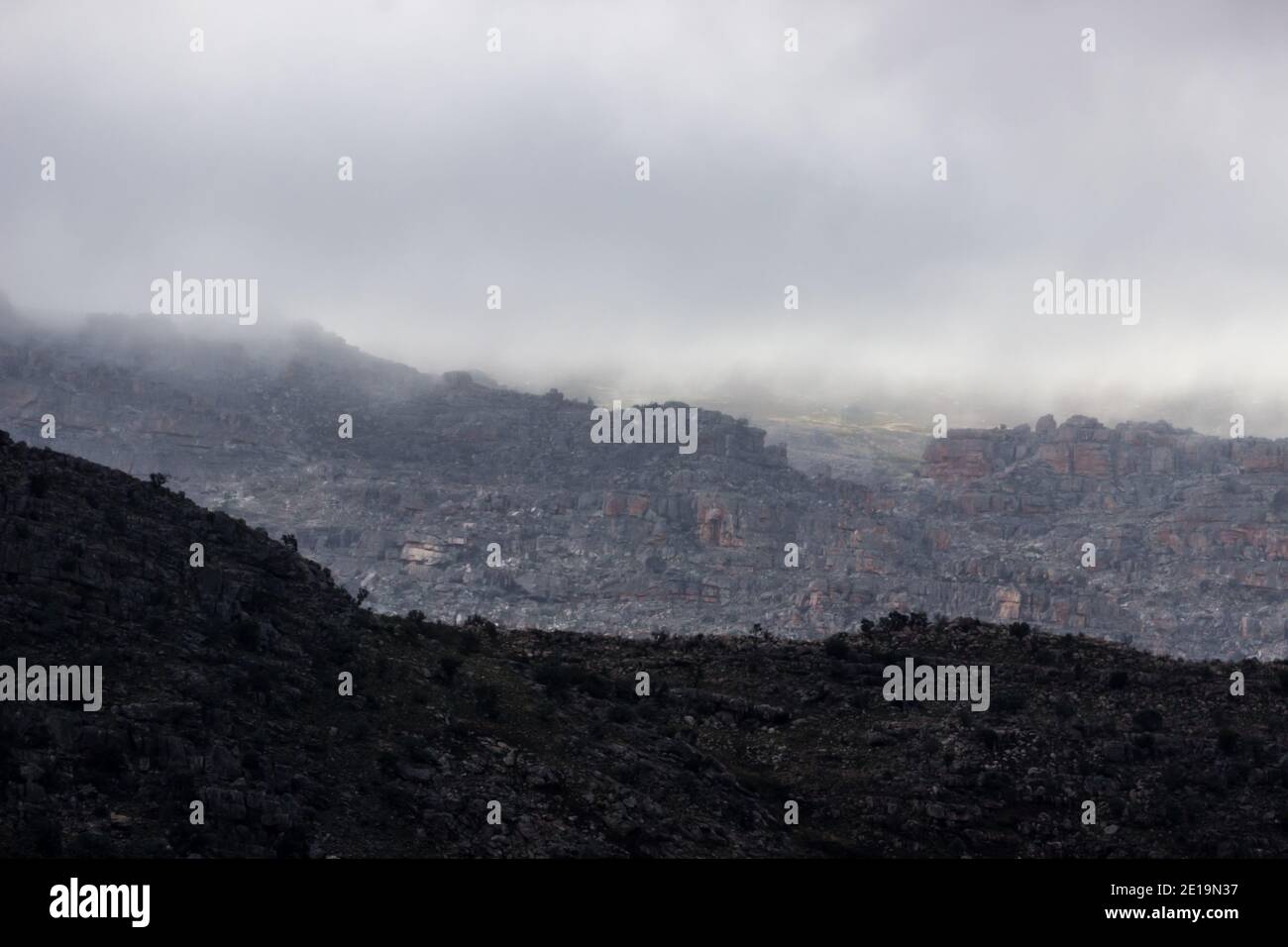 Le soleil du matin se brisant à travers des nuages de tempête menaçants et éclairant les crêtes supérieures des montagnes de Cederberg, en Afrique du Sud, avec l'arrière-pays Banque D'Images