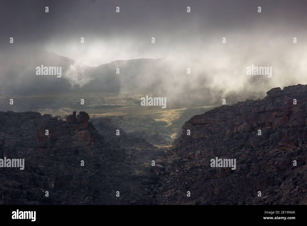 Le soleil du matin se brisant à travers des nuages de tempête menaçants et éclairant les crêtes supérieures des montagnes de Cederberg, en Afrique du Sud, avec l'arrière-pays Banque D'Images