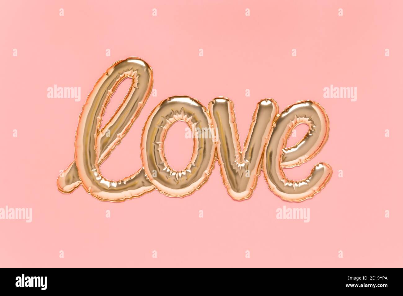 Mot d'amour écrit avec bulle en forme de feuille dorée brillante sur fond rose. Fête des mères, fête de la Saint-Valentin ou mariage. Vue de dessus, plan d'appartement Banque D'Images