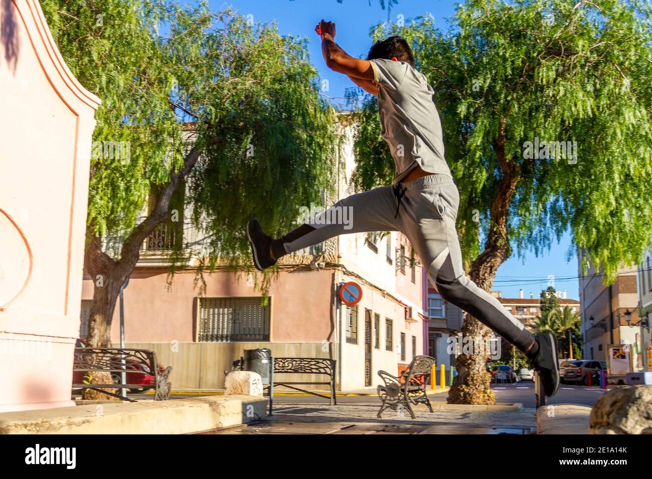 Active Latino jeune homme saut en action. Sport extrême, parkour extérieur gratuit course à pied ou concept de mode de vie sain Banque D'Images