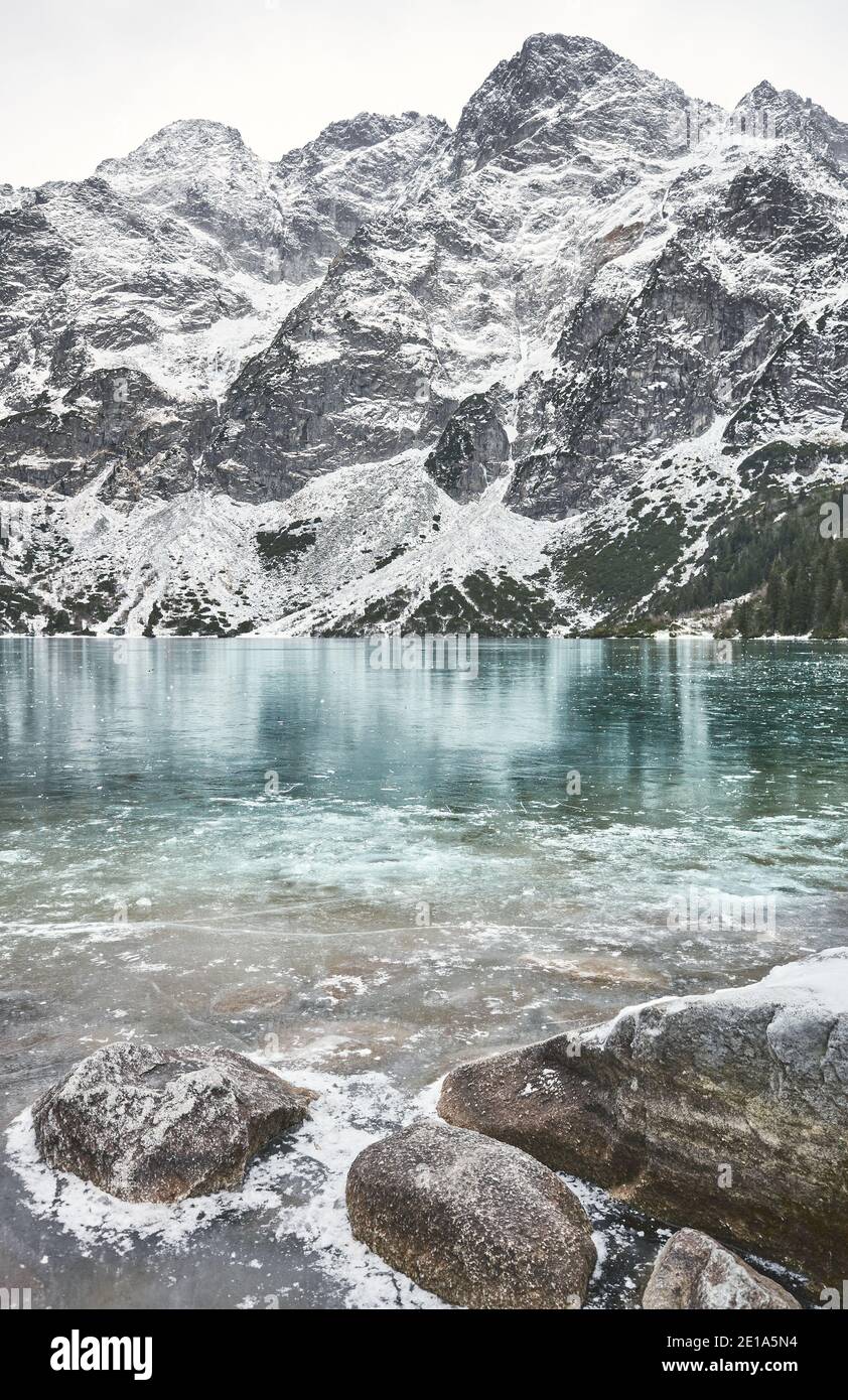 Lac Morskie Oko gelé (œil de la mer) par une journée enneigée dans le parc national de Tatra, Pologne. Banque D'Images