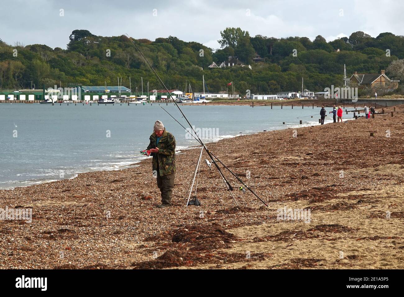 Un homme de pêche en mer de la plage préparant sa ligne Banque D'Images