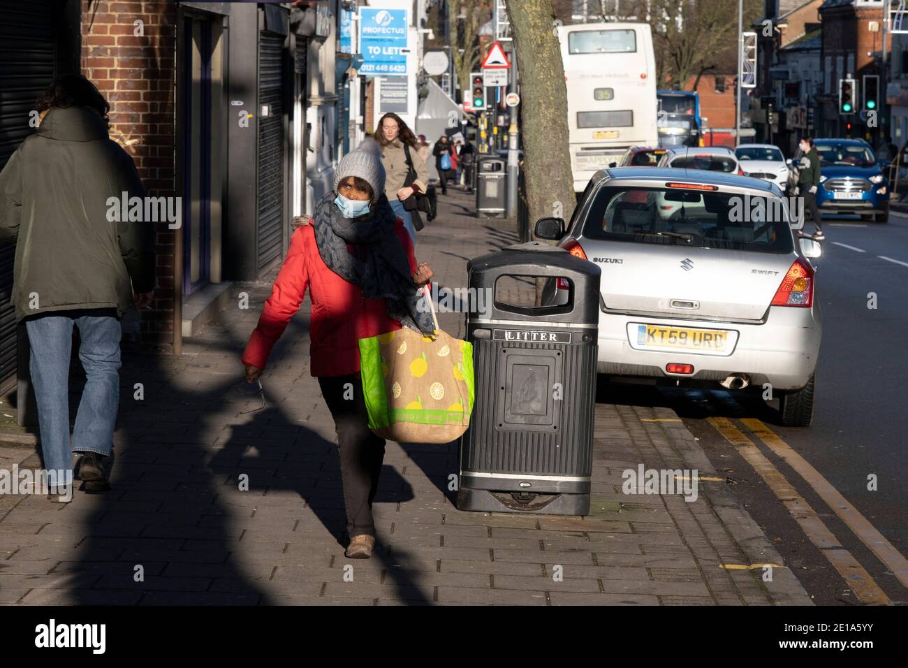 Le dernier jour de l'année, les gens qui font du shopping avec des masques marchent le long de Kings Heath High Street, car de nombreux magasins restent fermés, avec des volets en raison des restrictions de niveau 4 du coronavirus le 31 décembre 2020 à Birmingham, au Royaume-Uni. Les petites entreprises ont été confrontées à la pandémie de Covid-19 et nombre d'entre elles ont complètement fermé, alors que la récession s'aggrave au fur et à mesure que la crise se poursuit. Banque D'Images