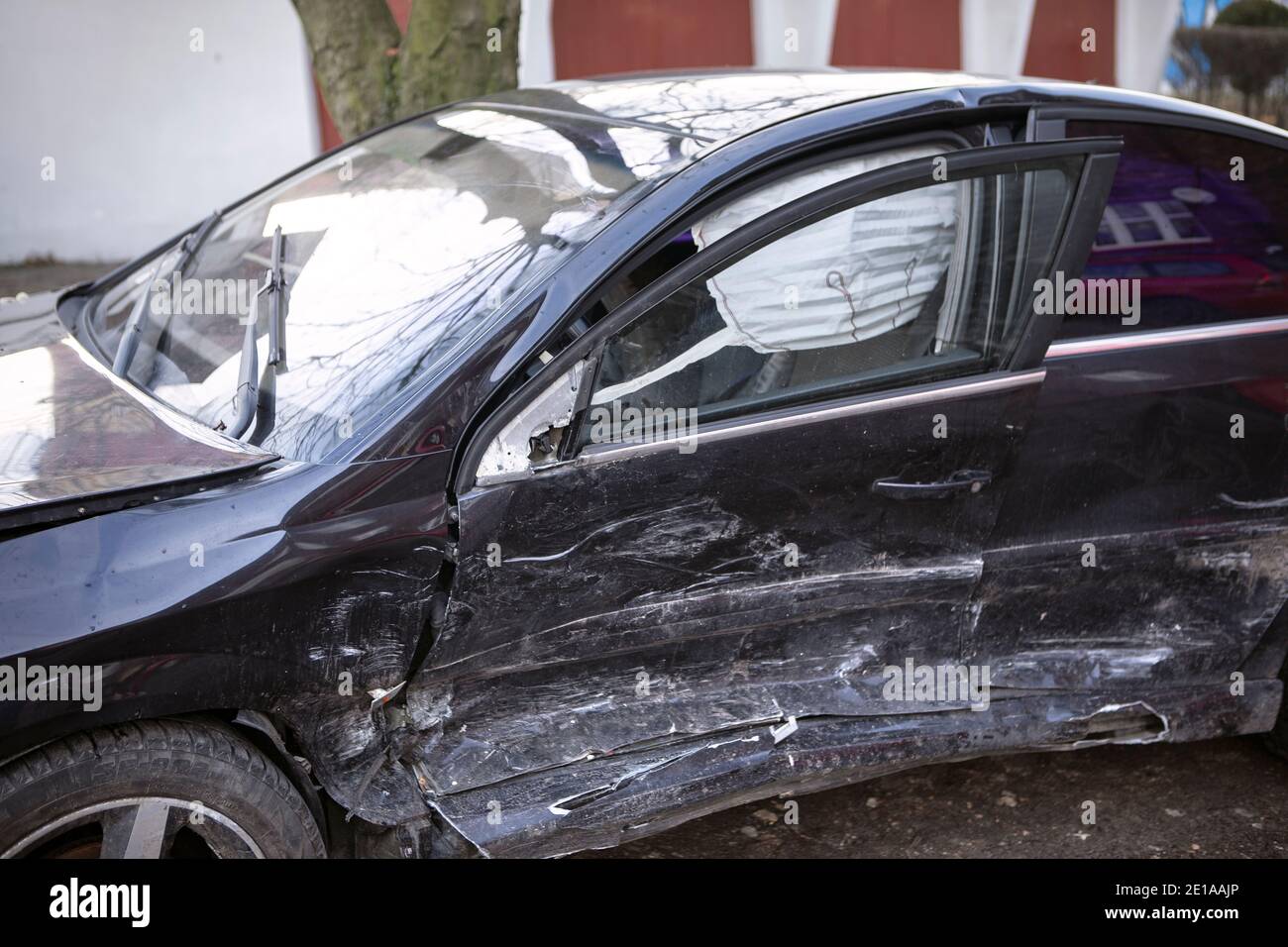 Voiture noire après accident. Véhicule accidenté en gros plan, vue latérale, sac gonflable visible. Banque D'Images