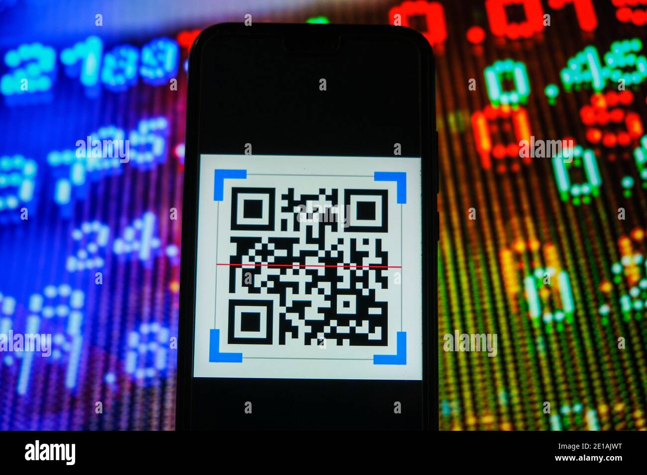 Dans cette illustration, un logo QR Code apparaît sur un smartphone avec les prix boursiers en arrière-plan. Banque D'Images