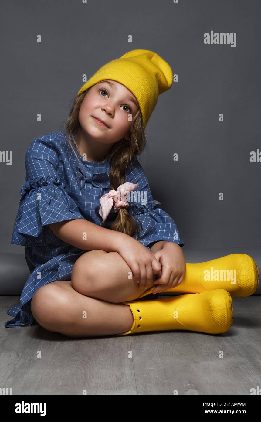 Petite fille modèle professionnellement posant dans le studio dans une robe et un chapeau jaune. Tests de modèles Banque D'Images