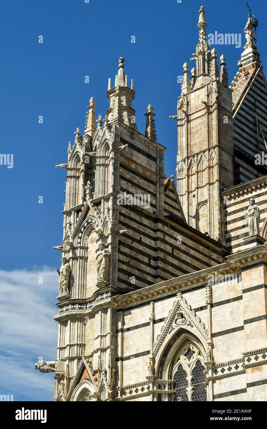 Partie supérieure de la partie droite de la cathédrale de Sienne (XIIIe siècle) de style roman-gothique contre ciel bleu, Toscane, Italie Banque D'Images