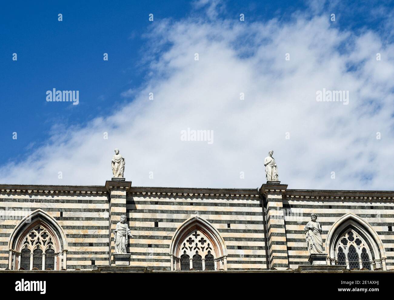 Partie supérieure du côté droit de la cathédrale de Sienne (XIIIe siècle) avec des fenêtres pointues et des statues de saints sur le dessus contre le ciel bleu, Toscane, Italie Banque D'Images