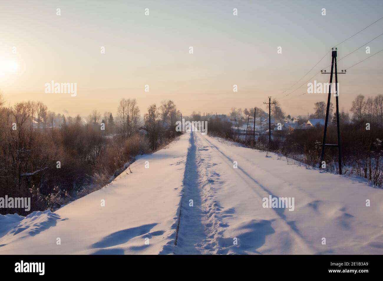 Un chemin de fer recouvert de neige et un chemin de fer trodden par les gens qui le font en hiver. Beaucoup de neige. Rails de fer une voie pour un train dans la direction de la cargaison couverte wi Banque D'Images