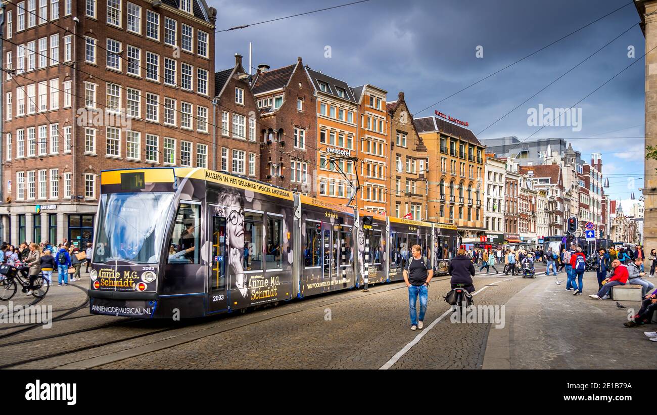 Touristes et un tramway sur la place animée du Dam dans le centre historique d'Amsterdam, aux pays-Bas Banque D'Images