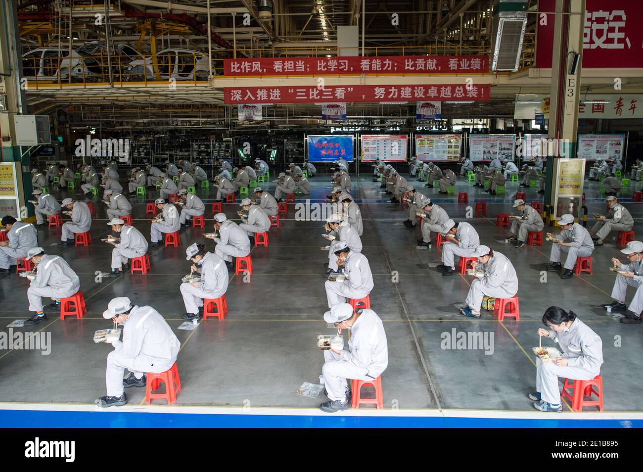 Pékin, province chinoise de Hubei. 24 mars 2020. Les travailleurs ont le déjeuner alors qu'ils gardent une distance de deux mètres à l'atelier de la Dongfeng Passenger Vehicle Company à Wuhan, dans la province de Hubei en Chine centrale, le 24 mars 2020. Credit: Xiao Yijiu/Xinhua/Alamy Live News Banque D'Images