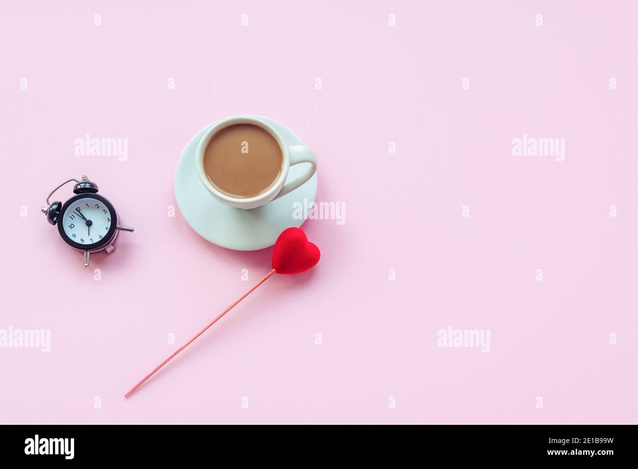 Une tasse de café, horloge et coeur jouet sur fond rose. Concept d'amour, Saint Valentin. Vue de dessus, plat, espace de copie. Banque D'Images