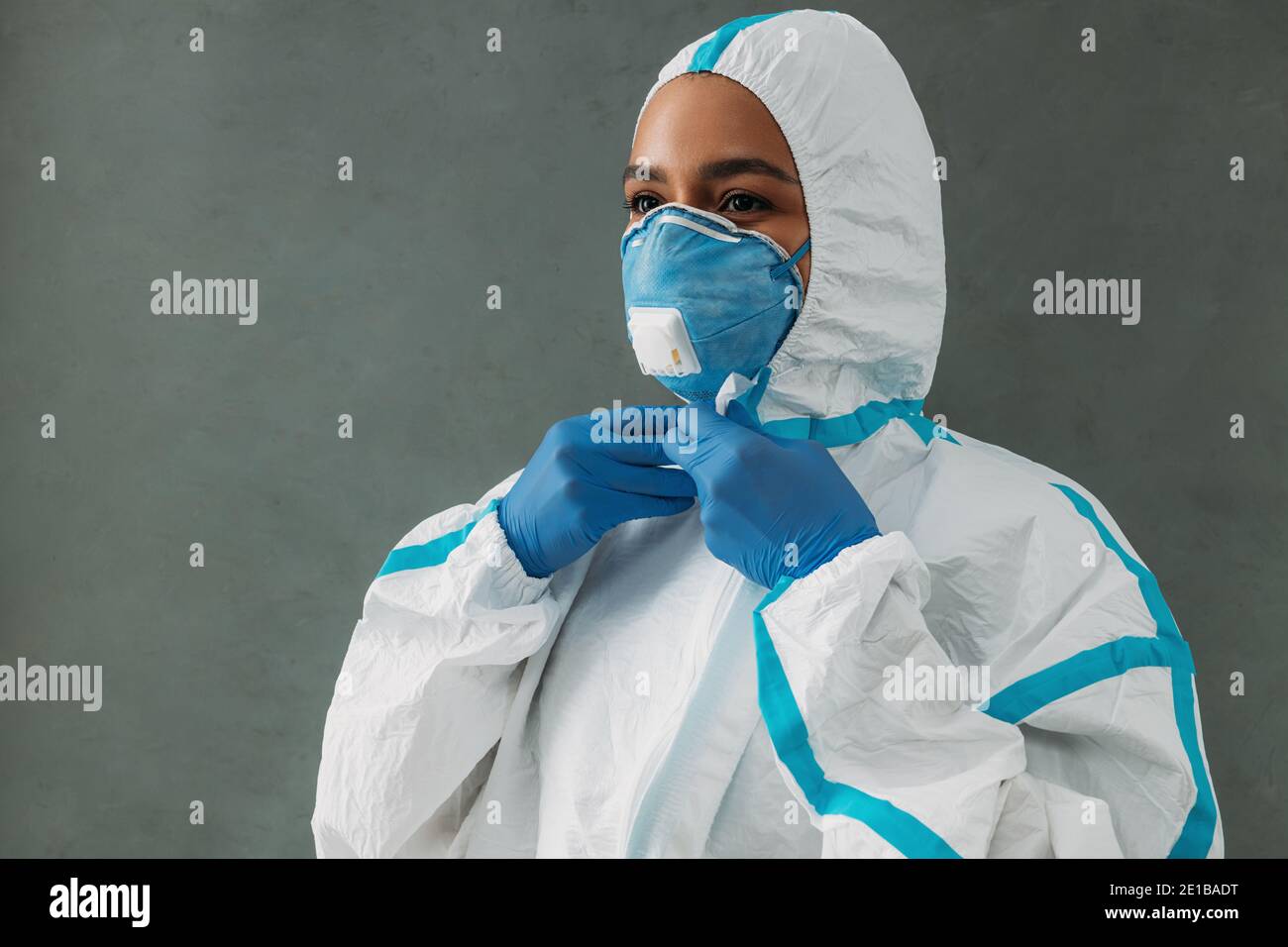 Spécialiste médical en train de fouetter la combinaison de protection en préparation du travail pendant une pandémie Banque D'Images