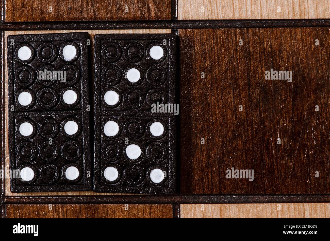 Dominos isolés sur un échiquier vintage en bois noir Banque D'Images