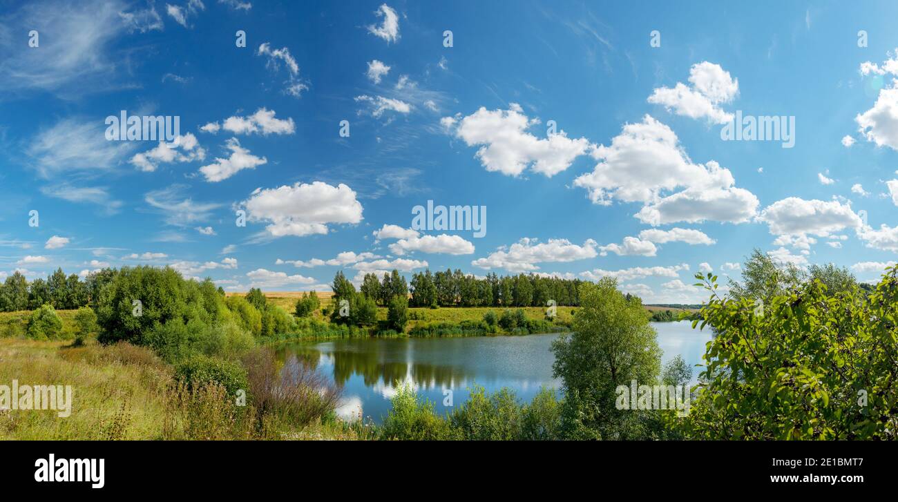 Paysage d'été panoramique lumineux avec beau lac et collines verdoyantes par beau temps Banque D'Images