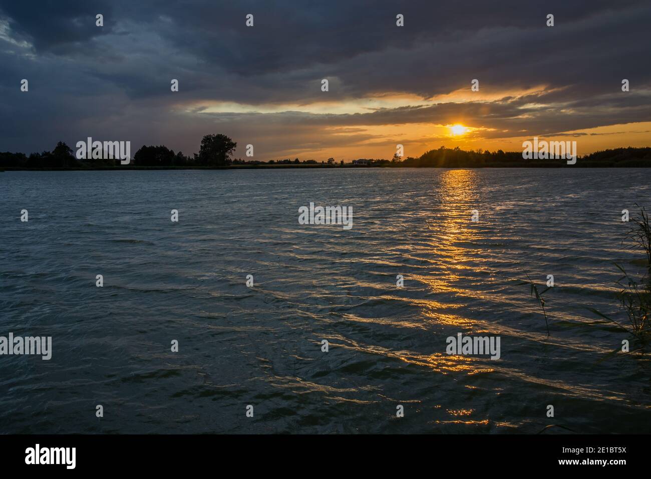 Coucher de soleil et nuages sombres sur le lac Banque D'Images