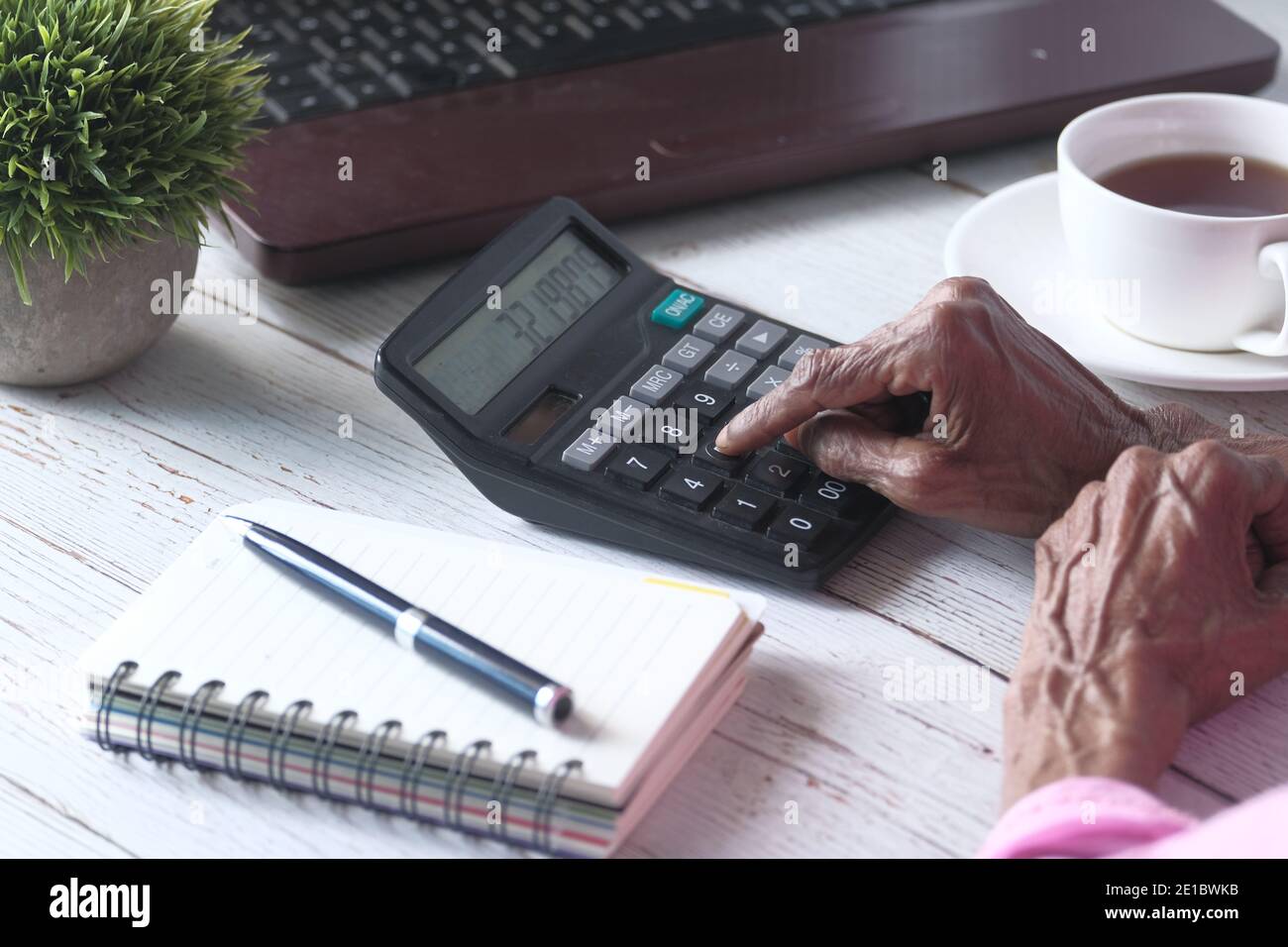 les femmes âgées se font main à l'aide de la calculatrice sur le bureau Banque D'Images