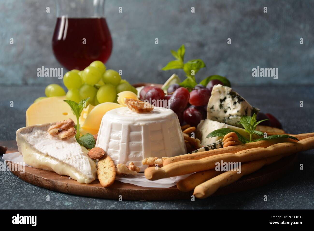 Plateau de fromages avec assortiment de fromages, raisins, noix et en-cas. Entrée au fromage français et italien. Concept traditionnel Shavuot Jewish Holiday Food Banque D'Images