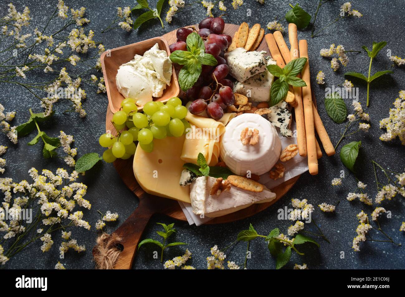 Plateau de fromages avec assortiment de fromages, raisins, noix et en-cas. Entrée au fromage français et italien. Concept traditionnel Shavuot Jewish Holiday Food Banque D'Images